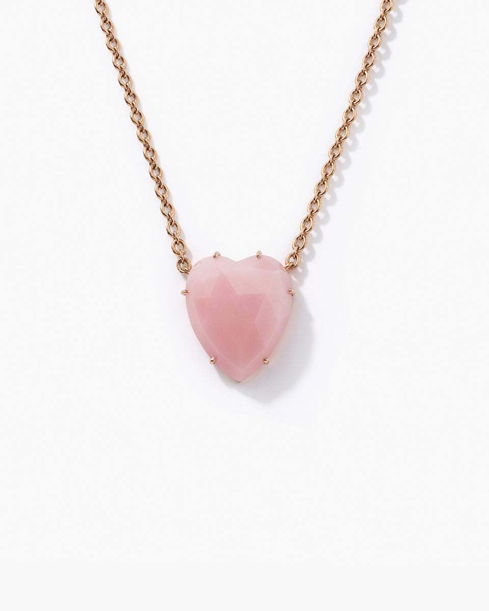 A heart-shaped pink gemstone pendant necklace on a delicate rose gold chain, photographed against a clean white background.