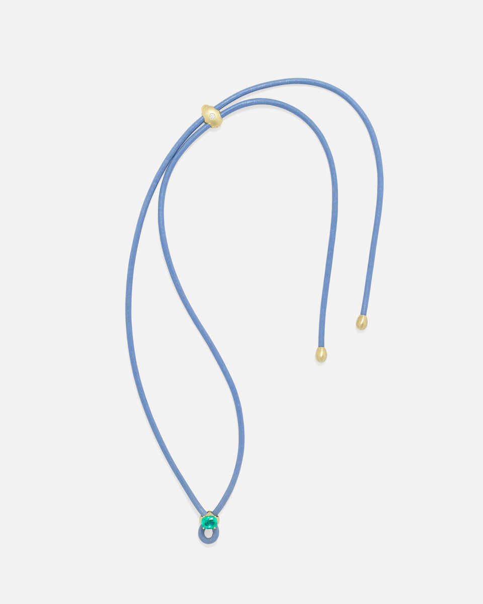 A double-strand purple cord necklace with small gold-toned beads and a small green and white bead accent at the pendant, displayed on a light gray background.