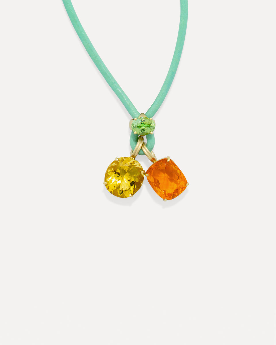 A mint green leather cord necklace with a gold-tone pendant featuring a round yellow gemstone and a cushion-cut orange gemstone, accented by a small green stone at the top.